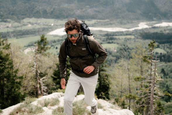 Man in sporty hiking clothes and sunglasses in a mountainous landscape